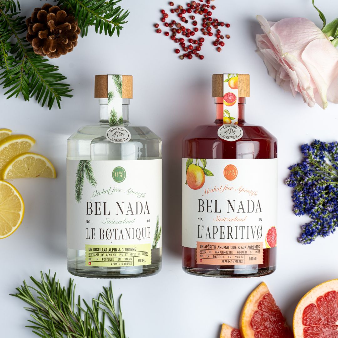 Bel Duo: Captivating Photo of Two Swiss Gems - Alcohol-Free Gin and L'Aperitivo. Immerse Yourself in the Harmonious Blend of Juniper, Pine, Lemon, Grapefruit, Rose, Lavender, and Rosemary. Elevate Your Refreshment Game with this Perfect Duo of Trendy, Health-Conscious Choices. The Image Showcases the Alluring Bottles, Promising a Flavorful Journey.